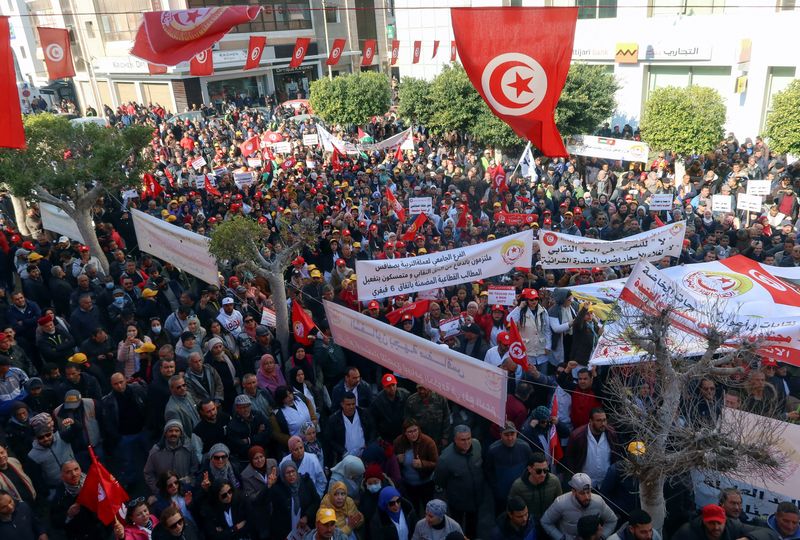 Сторонники Всеобщего профсоюза тунисских трудящихся (UGTT) несут транспаранты и флаги во время акции протеста против политики президента Каиса Саида, обвиняя его в попытке подавить основные свободы, включая права профсоюзов. Сфакс, Тунис 18 февраля 2023